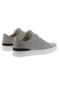 Zapatillas de cuero gris con una textura lisa, diseño bajo, suela de goma blanca y detalle negro en el talón. Presentan un cierre con cordones.