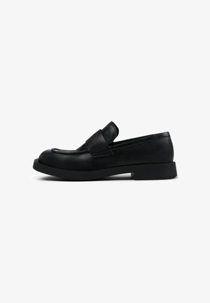 Mocassins en cuir noir avec une semelle basse et épaisse ; présentent une large lanière sur le dessus et un bout arrondi ; finition texturée.