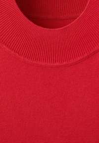 Gros plan d'un pull rouge en maille avec un col rond côtelé et un tissu en maille lisse sur le corps.