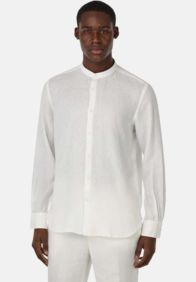 Camicia bianca in lino a maniche lunghe con colletto alla francese, chiusura con bottoni frontali e orlo dritto. Tessuto leggermente trasparente, vestibilità aderente.