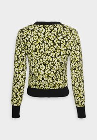 Pull noir avec un motif floral jaune, col et poignets côtelés. Coupe ajustée avec un ourlet court à l'arrière.
