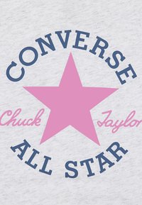 Il tessuto grigio presenta una grande stella rosa con "CONVERSE" e "ALL STAR" in blu navy, e "Chuck Taylor" in rosa, stampati in un layout circolare.