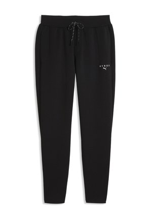 Czarne spodnie dresowe typu jogger ze ściągaczem w pasie i małym białym logo HYROX Puma na górnej lewej części uda, rozłożone płasko na białym tle.