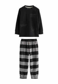 Haut à manches longues noir avec texte imprimé ; associé à un pantalon à carreaux gris et noir avec des poignets et une taille élastiques pour plus de confort.