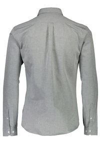 Chemise droite grise avec un col, des manches longues et un tissu texturé. Dotée d'un pli dans le dos pour plus de mouvement et de boutons blancs.
