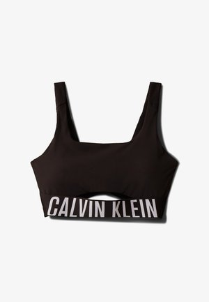 Czarny sportowy stanik z kwadratowym dekoltem i szerokimi ramiączkami. Posiada fakturowaną górę i kontrastowe białe logo "CALVIN KLEIN" na pasku.
