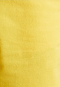 Texture de tissu jaune avec un tissage diagonal subtil et un éclairage doux, présentant de légers plis sur toute la surface.
