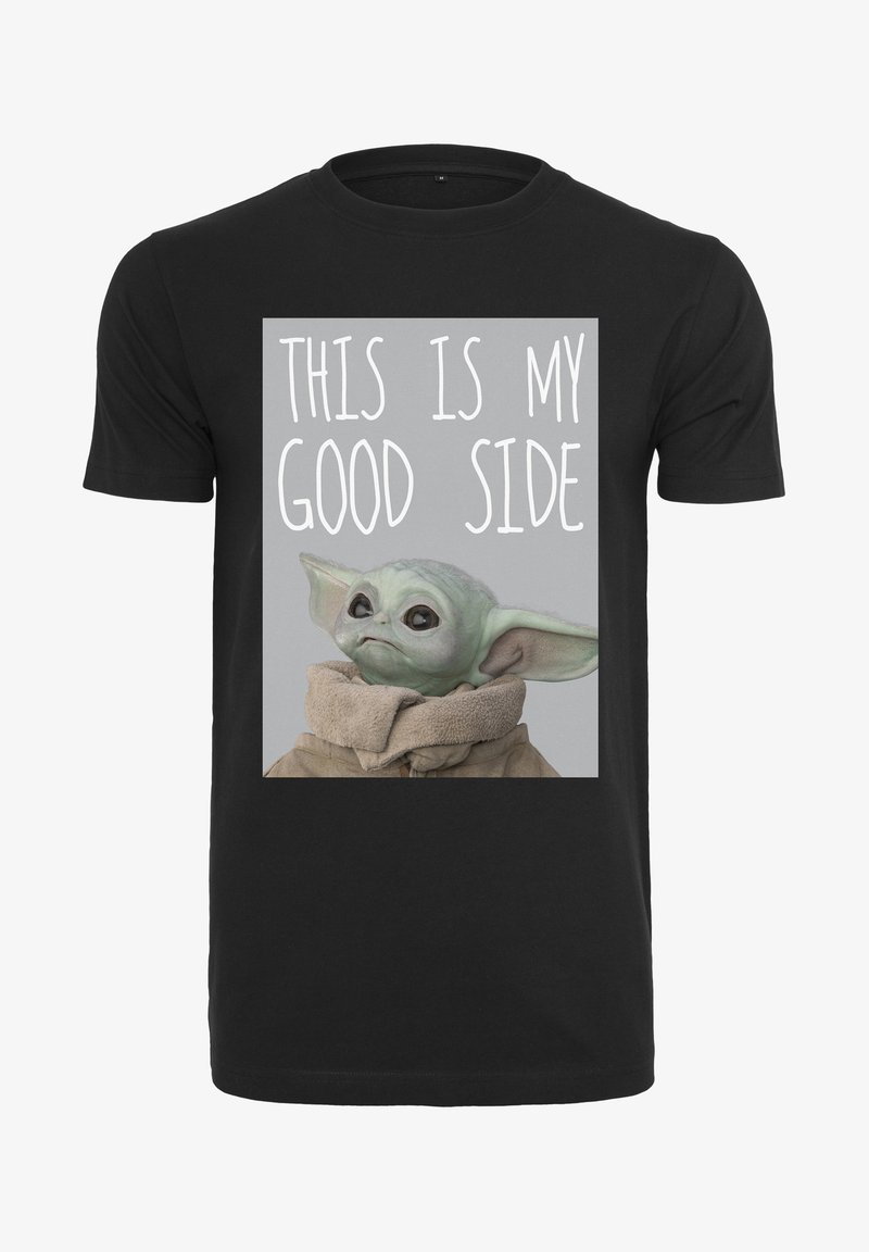 Juodas marškinėlis, vaizduojantis žalią personažą su didelėmis ausimis, vilkintį bežadžio apsiausto kostiumą, ir tekstą: "Čia yra mano gera pusė."