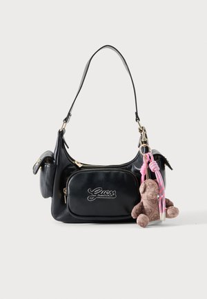 Sac à épaule Guess en cuir noir avec poche avant zippée, poches latérales et porte-clés ours en peluche marron avec cordons roses.