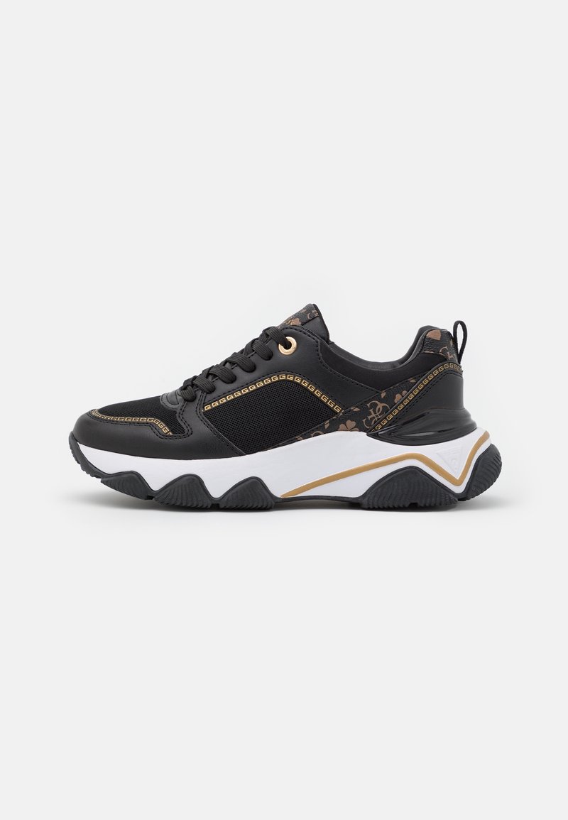 Scarpe sportive nere con una tomaia in mesh e sintetico, dettagli dorati, suola bianca chunky e decorazioni laterali a pattern.