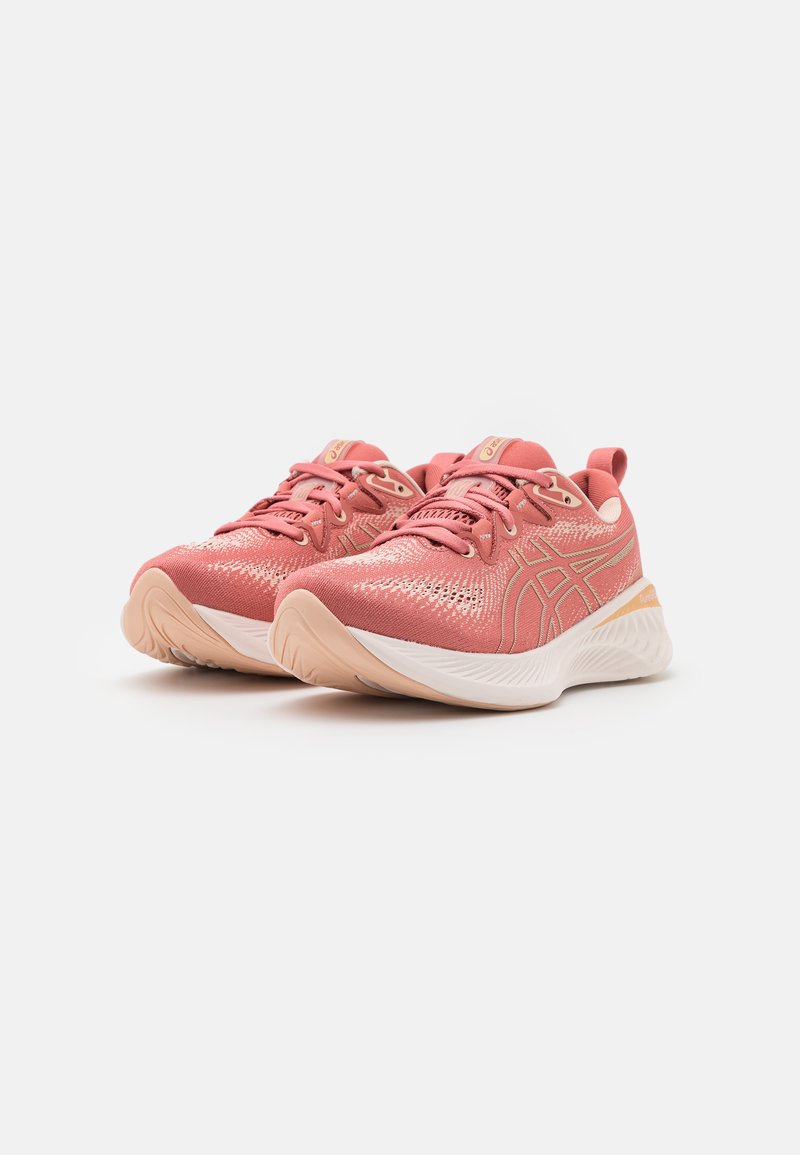 Rosa Sportschuhe mit einem atmungsaktiven Mesh-Obermaterial, goldenen Akzenten, gepolsterter Zunge und einer strukturierten weißen Zwischensohle mit einer Gummisohle.