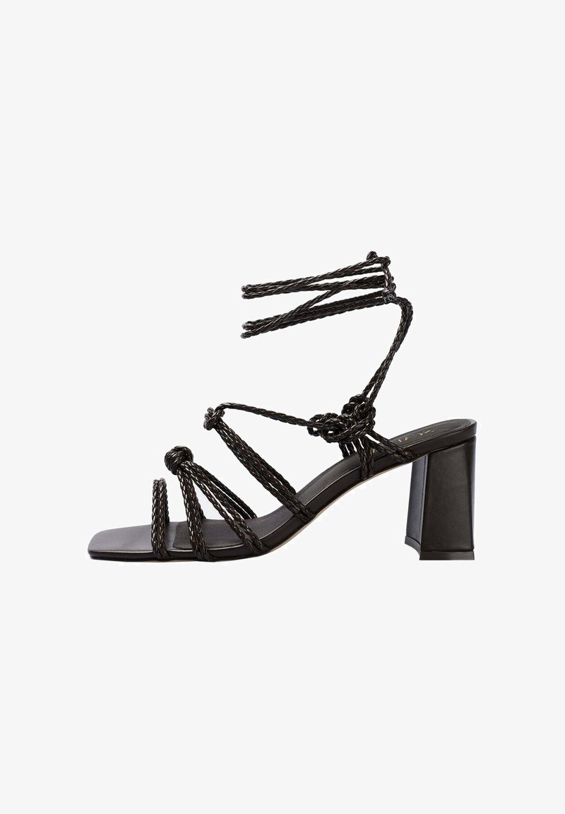 Zwarte hielsandalen met gevlochten banden, een chunky blokhak en een platte vierkante teen. Gemaakt van soepel leer met een gestructureerde afwerking.