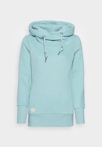 Ljusblå hoodie med cowl-krage, justerbara dragkedjor och ribbade manschetter. Har en broderad logotyp och en liten etikett i botten.