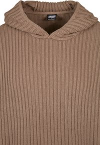 Hoodie brun en maille côtelée avec un col épais et rabattable. Confectionné dans un matériau doux, il présente un design décontracté et une surface texturée.