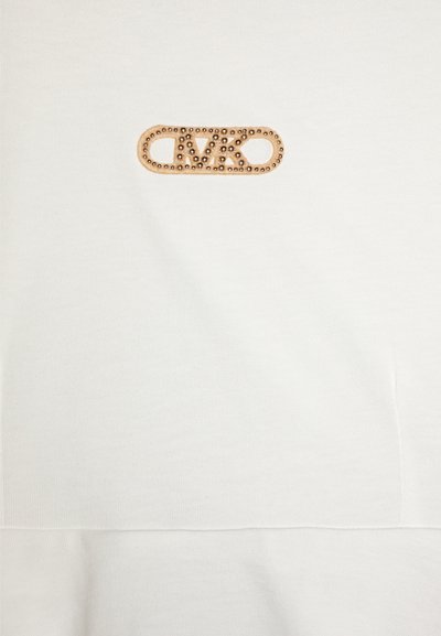 Sweatshirt en coton blanc avec un accent de logo en métal doré et une bordure décorative à pois. Design simple et texture lisse.