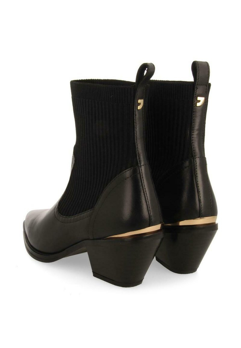 Botines de cuero negro con laterales de textil acanalado, puntera redondeada y un tacón apilado acentuado con una franja dorada.