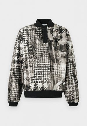 Πουλόβερ με μακριά μανίκια, μαύρο γιακά και μανσέτες, με ασπρόμαυρο αφηρημένο σχέδιο ημίτονας και υφασμένο μοτίβο.