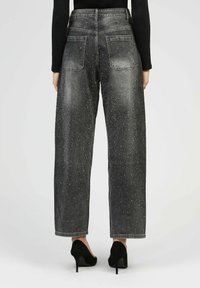 Jeans en denim noir taille haute avec une coupe légèrement relaxée, ornés de strass dispersés et de poches arrière standard.