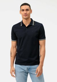 Polo shirt navy in cotone, con colletto e polsini a righe in contrasto, apertura a tre bottoni e design aderente.