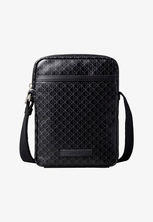 Crna torbica na rame s ponavljajućim geometrijskim uzorkom, prednji džep sa zatvaračem, podesivim pamučnim remenom i pločicom s logom Calvin Klein na prednjoj strani.