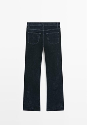 Mørk denimjeans med lige ben, udstyret med en midtstigning i taljen og to baglommer, der viser en glat og tekstureret overflade.