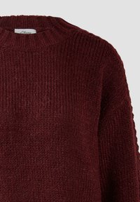 Ciemnoczerwony sweter wykonany na drutach z żeberkowym okrągłym dekoltem oraz teksturowanym wzorem.