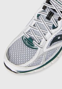 Lightweight running shoe; mesh upper in grey with green accents, intricate diamond pattern, white laces, cushioned sole, and logo detail.