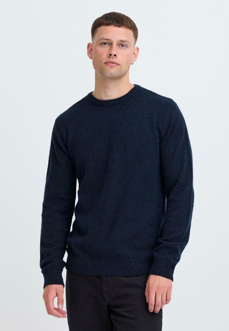Marineblauer Strickpullover mit rundem Halsausschnitt, langen Ärmeln, gerippten Bündchen und Saum, der eine weiche Textur und eine lässige Passform bietet.