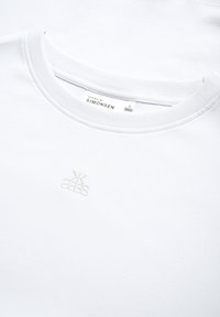 Witte T-shirt met ronde hals van katoen, met een subtiel geborduurd logo op de borst en een label dat maat M aangeeft.