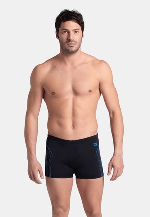 Bañador negro de hombre con acentos azules. Diseño elegante, forma ajustada, fabricado con material elástico. Presenta un logo en la cintura.