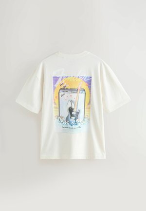 T-shirt en coton blanc avec un motif représentant une guitare, un ampli et des fleurs. Manches courtes et coupe décontractée. Design imprimé au dos.