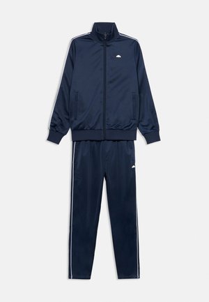 Veste de survêtement bleu marine zippée intégralement avec deux poches et pantalon assorti, tous deux avec des bandes blanches sur les côtés et de petits logos blancs.