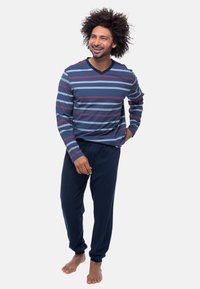 Maglietta a maniche lunghe a righe con scollo a V in blu navy, blu e rosso; abbinata a pantaloni lounge blu navy. Tessuto morbido, vestibilità comoda, vita elastica.