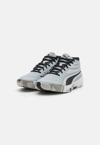 Light blue athletic shoes with black accents, textured surface, lace-up design, and a gray camo-patterned sole.