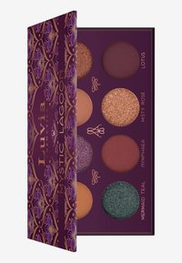 Lidschattenpalette mit acht Farbtönen in Erdtönen, darunter matte, schimmernde und glitzernde Finishes. Verfügt über eine kunstvolle lila Verpackung mit goldenen Akzenten.