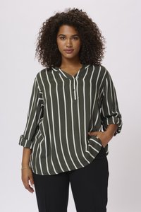 Blouse à rayures vertes et blanches avec un col en V, détails de boutons et manches retroussées, fabriquée dans un tissu lisse, offrant un ajustement décontracté.