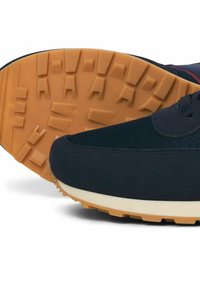 Baskets bleu marine avec une tige en mesh texturé, une semelle rembourrée et une semelle extérieure en caoutchouc avec des rainures profondes pour une meilleure adhérence.