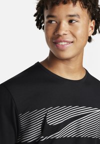 Camiseta deportiva negra con tejido texturizado, cuello redondo y un gráfico de rayas horizontales en plata a lo largo del pecho.