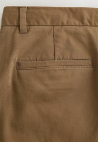 Bruine stoffen broek met een gladde textuur, voorzien van een achterzak met subtiele horizontale stiksels en een standaard tailleband.