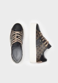 Sneakers in pelle nera con un pannello laterale marrone decorato, lacci dorati e suola piatta bianca. Dettagli testurizzati sul tallone.