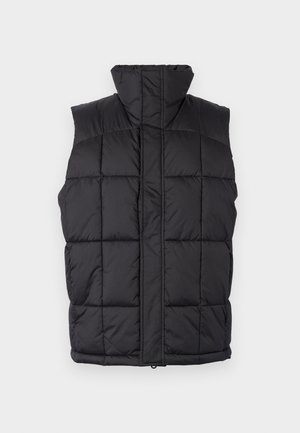 Gilet rembourré noir avec un col haut, texture matelassée et fermeture éclair à l'avant. Sans manches, comportant des lignes cousues horizontalement pour l'isolation.