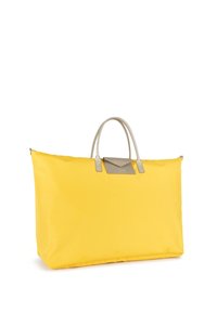Grande borsa a tracolla gialla realizzata in tessuto resistente, con manici in pelle beige e un accento in pelle coordinato sul fronte.