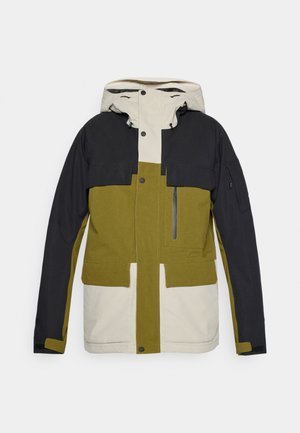 Krāsu bloku jaka ar melniem, tumši zaļiem un krēmkrāsas elementiem. Iekļauj kapuci, vairākas kabatas un rāvējslēdzēju. Izturīga auduma tekstūra.