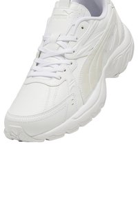 Scarpa sportiva bianca con tomaia in pelle e rete, dettagli testurizzati, suola arrotondata e logo del marchio prominente sulla linguetta.