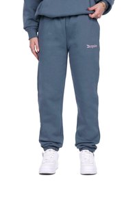 Blå bomulds-sweatpants med elastiske cuffs og talje, med broderet tekst "Dropsie" i lys pink på venstre hofte.