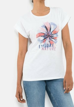 T-shirt en coton blanc avec des manches retroussées, ornée d'un design floral coloré et du texte "EXPLORE NATURE" en bleu et rose.