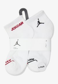 Șosete albe până la gleznă în pachet de 6. Prezintă text roșu și negru "JORDAN" și logo siluetă. Material din amestec de bumbac cu margini striate.
