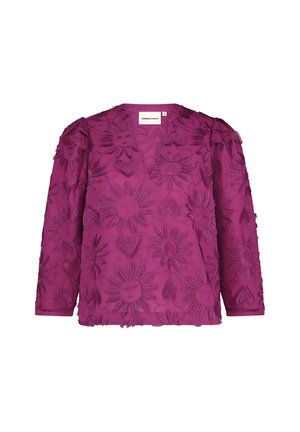 Fuchsia blouse featuring floral and sunburst embroidery, long sleeves, and a v-neckline. Textured fabric with frayed edges.