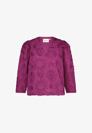 Fuchsia blouse met bloem- en zonnestraalborduursels, lange mouwen en een v-halslijn. Getextureerde stof met rafelige randen.