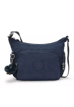 Sac bandoulière bleu marine avec poche avant zippée, fermeture latérale, sangle ajustable et un petit porte-clés singe en peluche attaché.